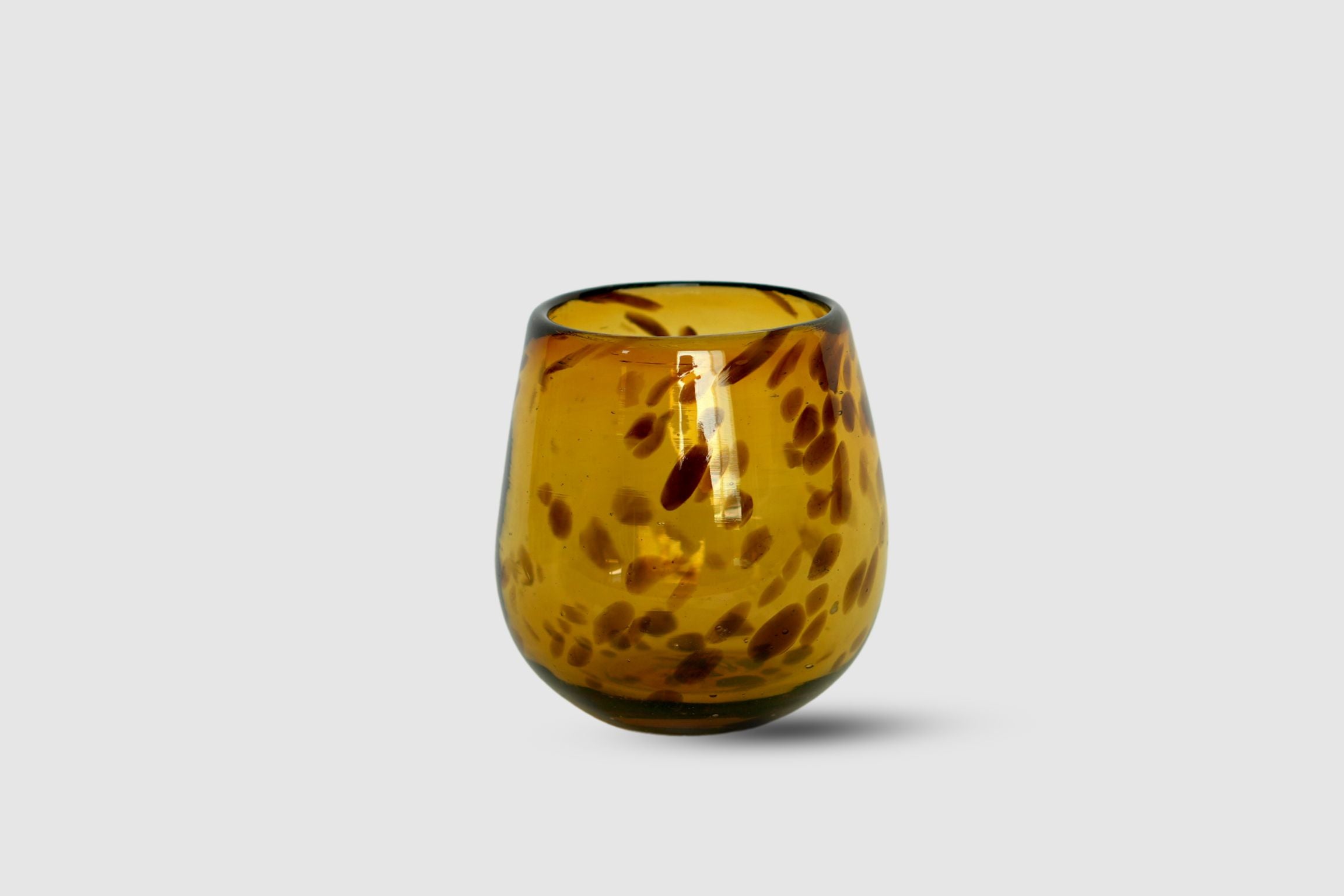 Amber drop tumbler with dotted bead-like pattern on white background