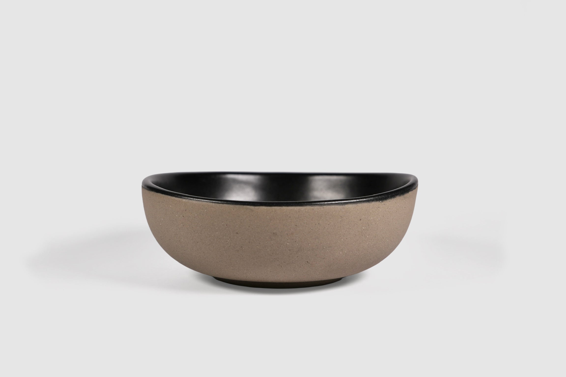 Bowl Sanka by Humo 1810 – black semi-matte stoneware, unglazed exterior, soft triangular form, 6.25 inch