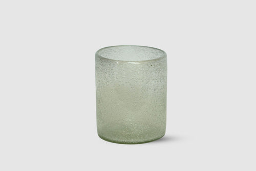 Short highball glass with trapped air bubbles on white background