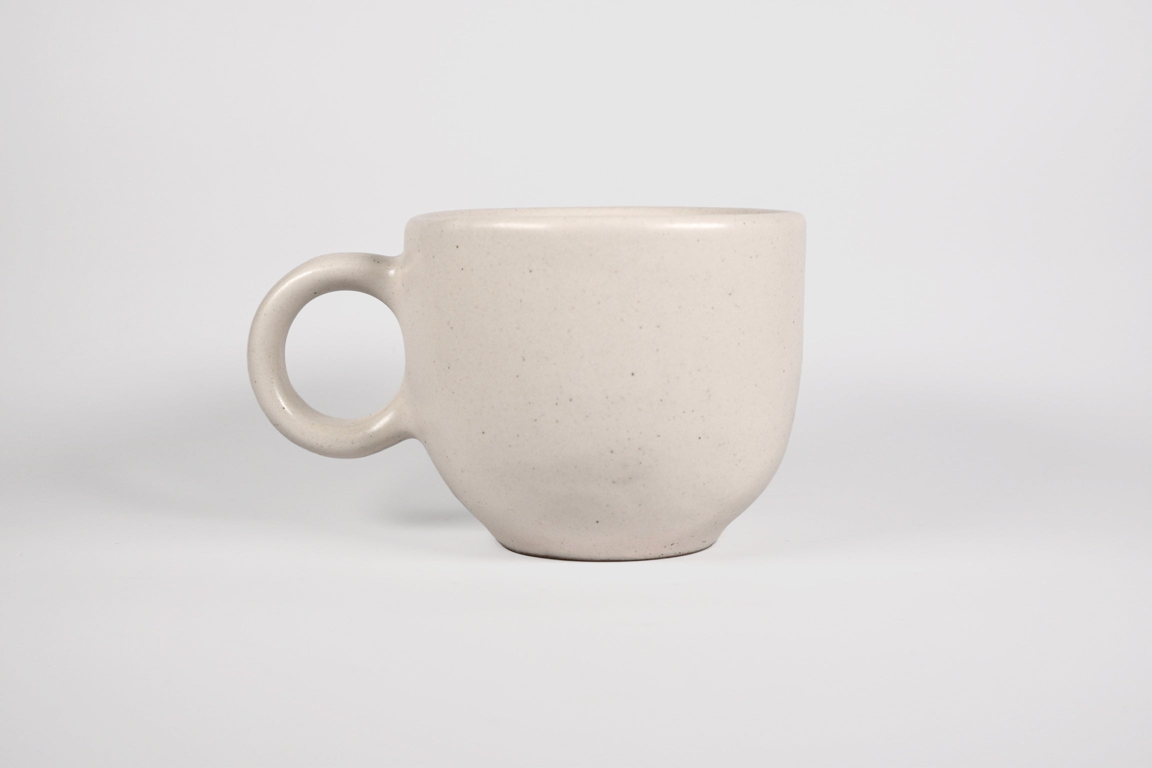 Rounded cappuccino mug with spherical body and circular ring handle in Pardo