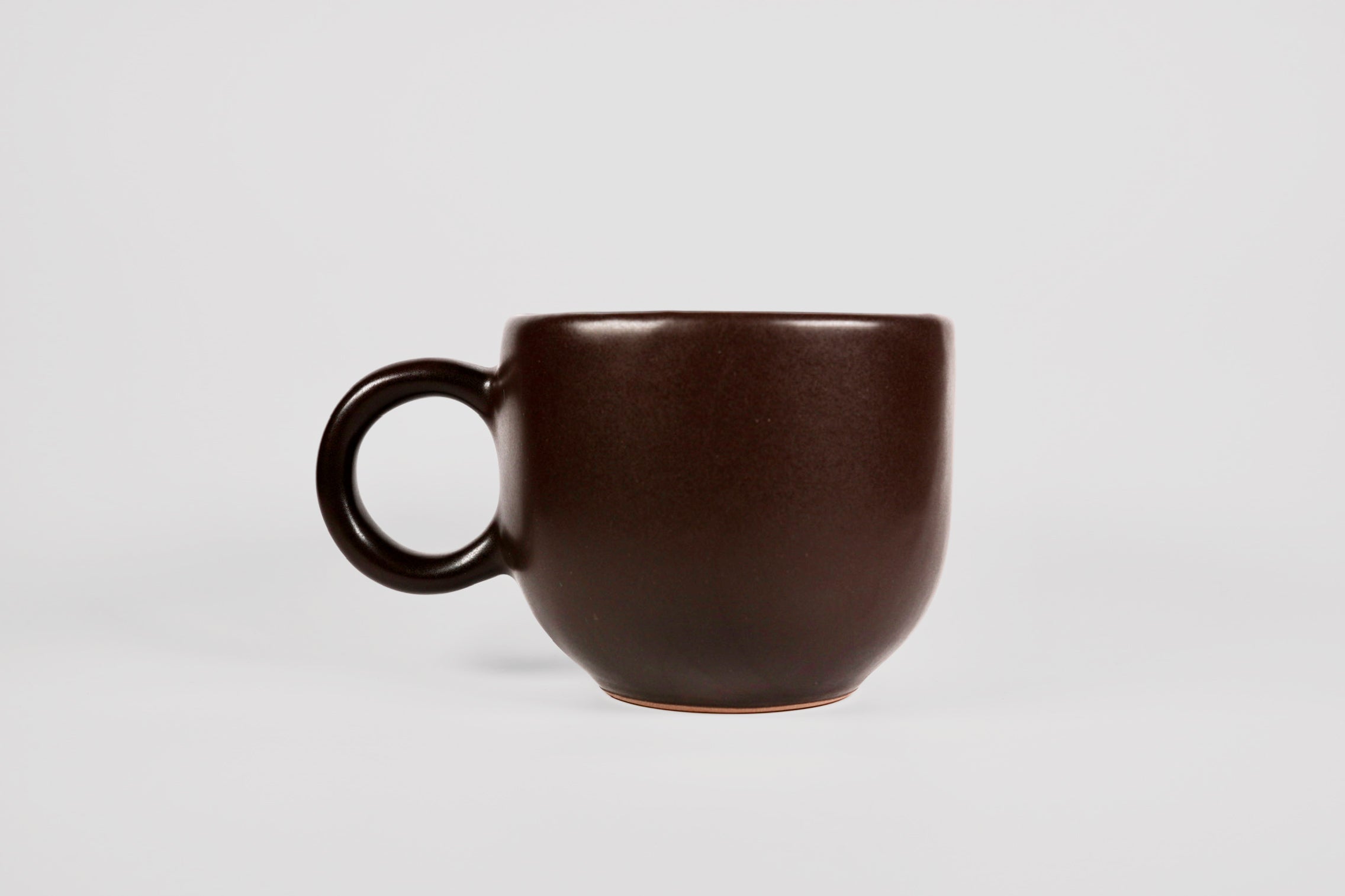 Rounded cappuccino mug with spherical body and circular ring handle in Pardo