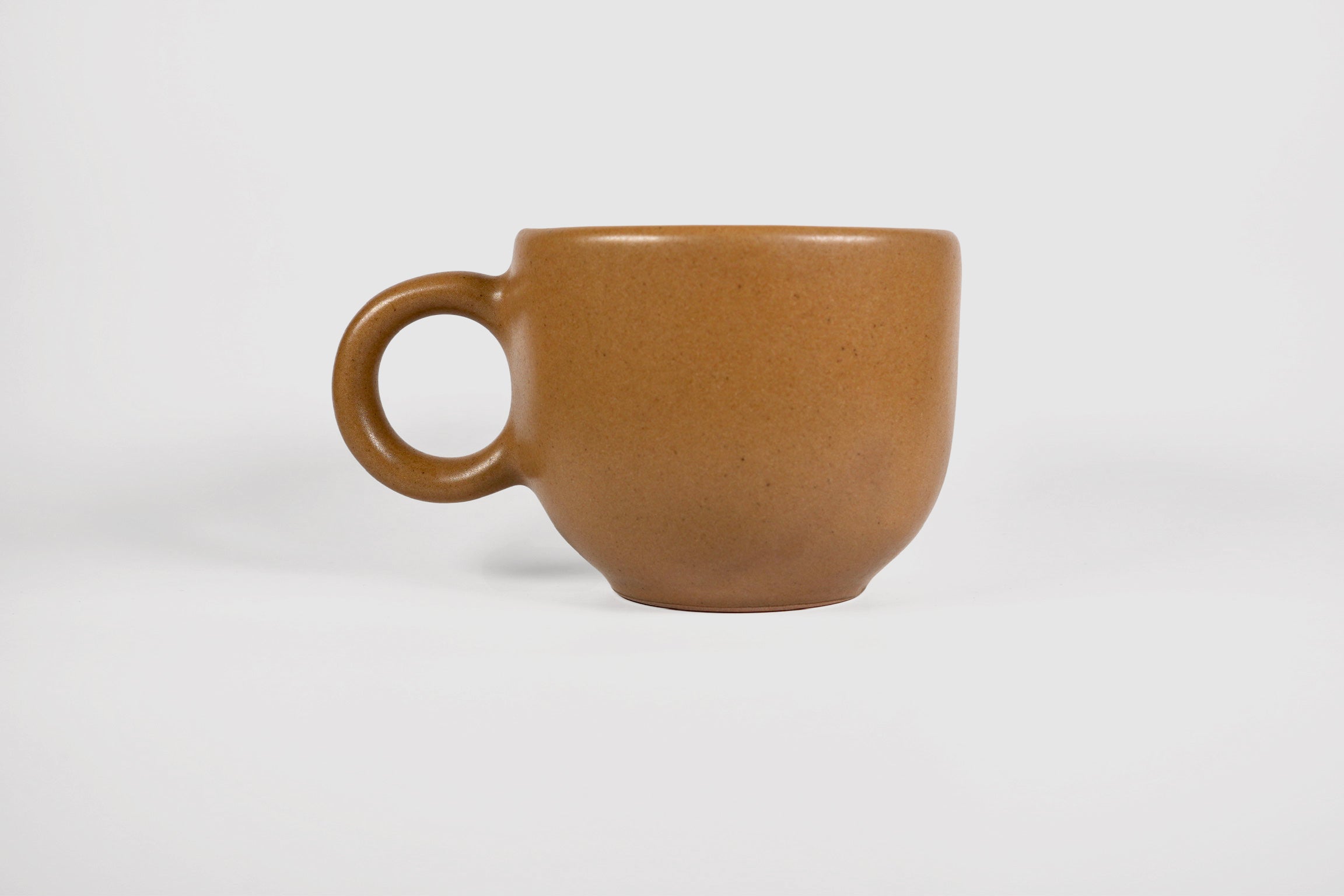 Rounded cappuccino mug with spherical body and circular ring handle in Pardo