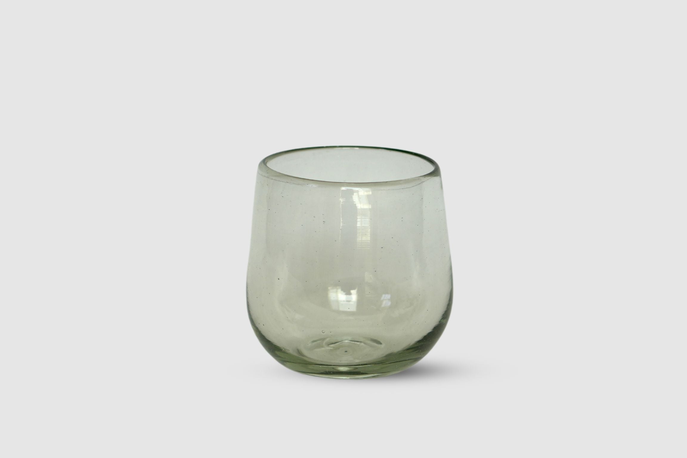 Clear hand-blown drop-shaped tumbler on white background