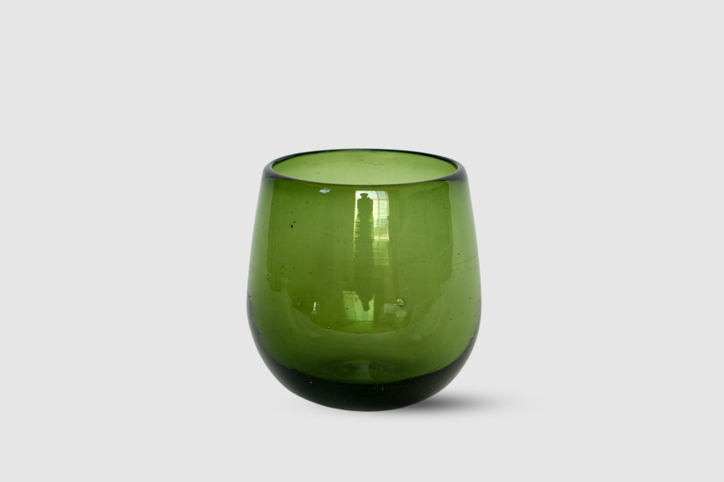 Olive-tinted drop-shaped hand-blown tumbler on white background