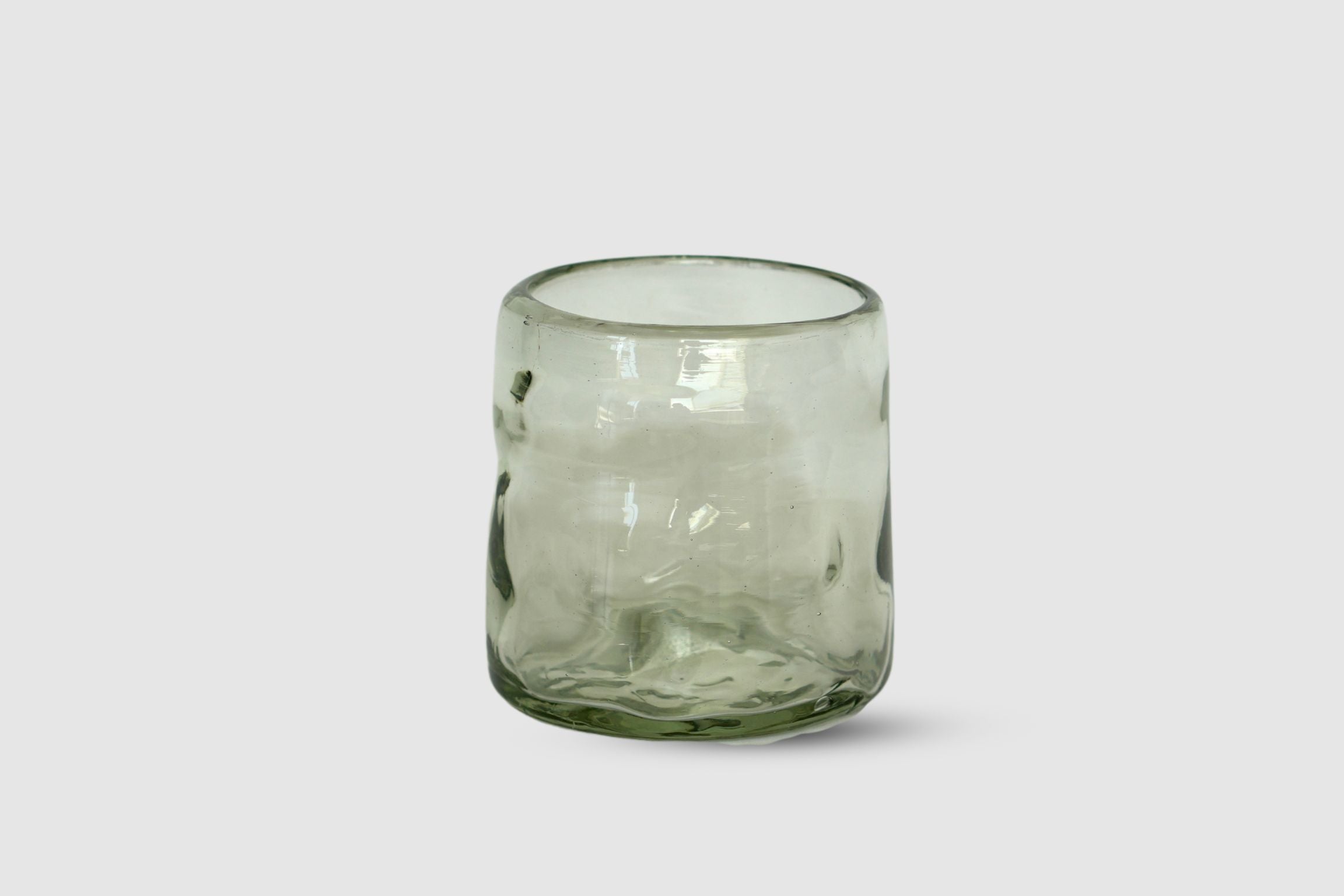 Clear hand-blown short highball with organic irregular silhouette on white