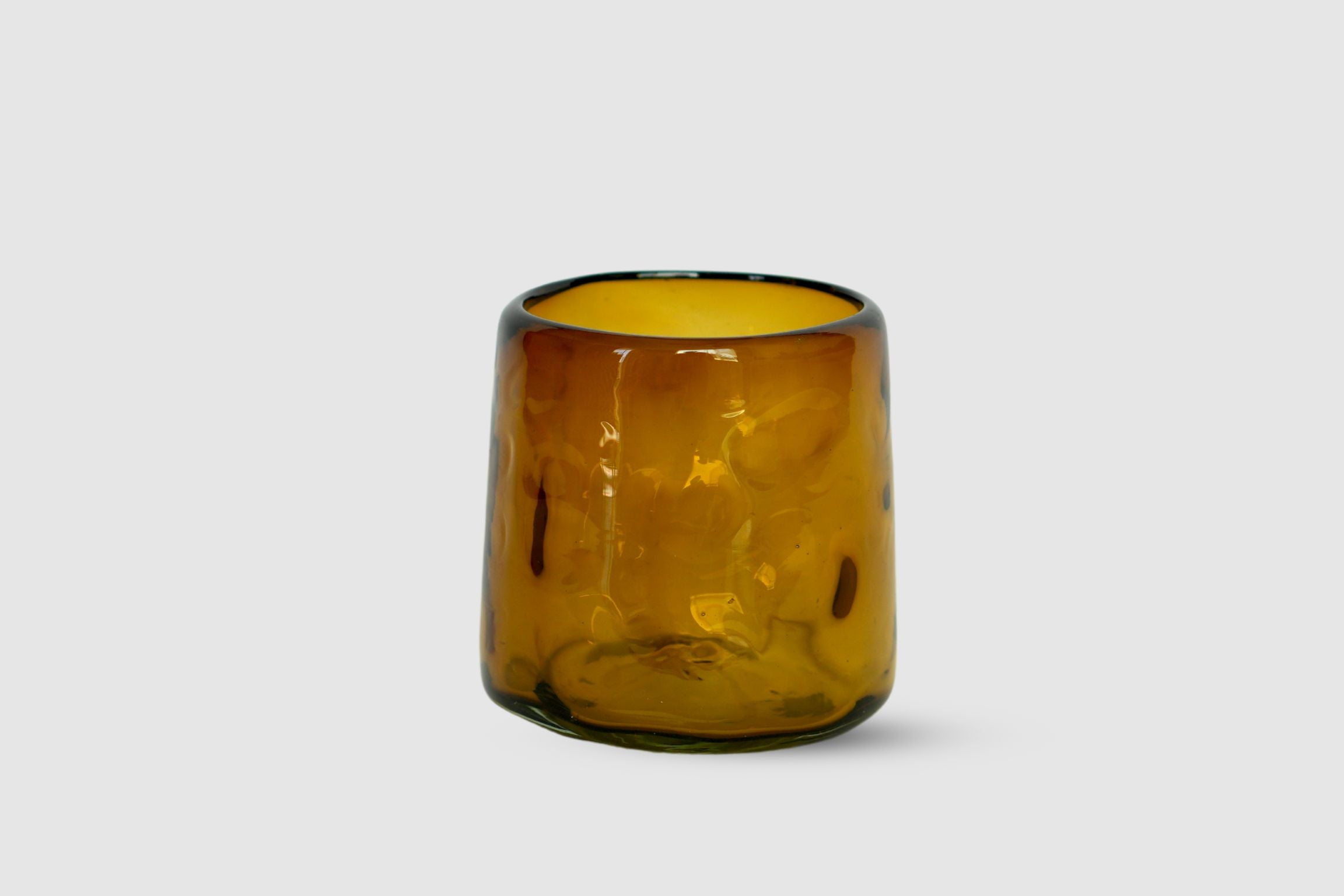 Amber hand-blown short highball with organic hand-made silhouette on white