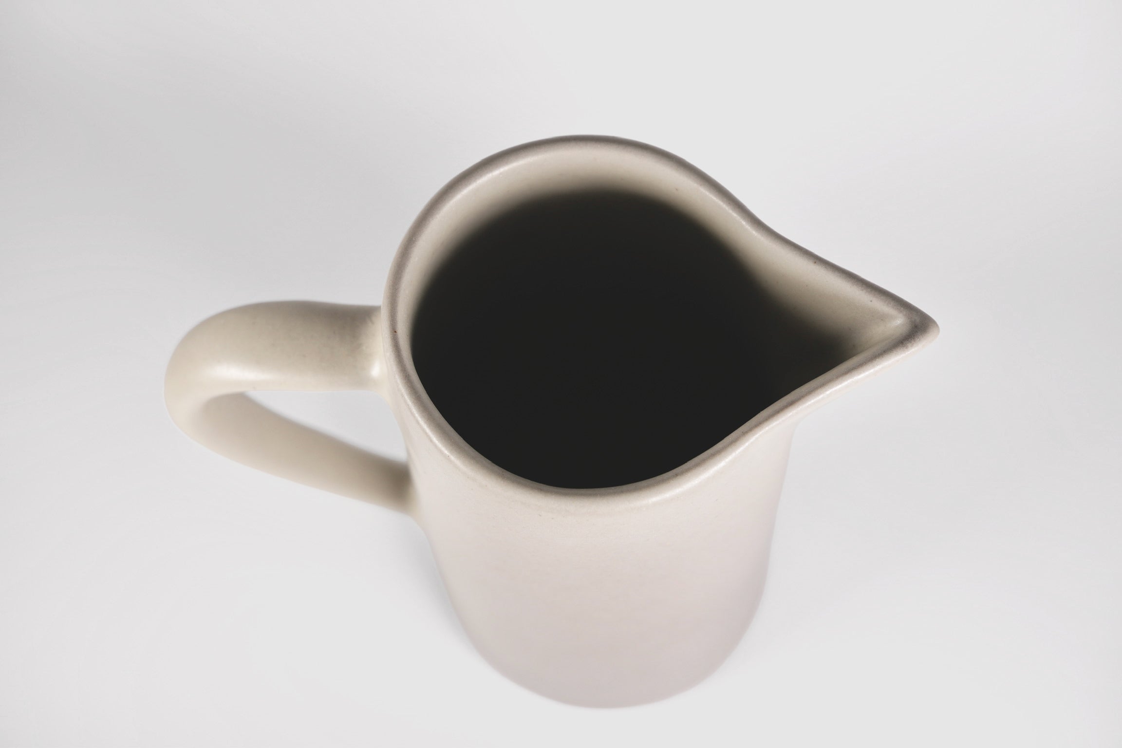Tall Rojizo ceramic pitcher with tapered body, pouring lip and pulled handle
