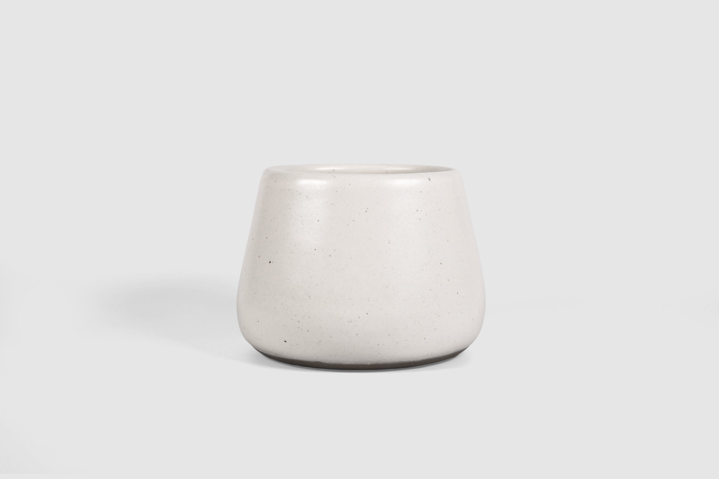 Squat stoneware tumbler, low belly, softly rolled matte rim.